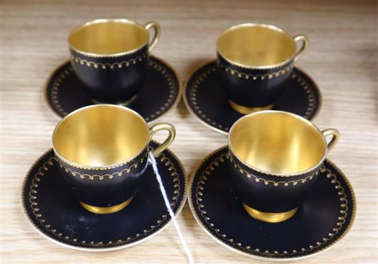 A set of four miniature Royal Worcester cups and saucers, in black and gilt design